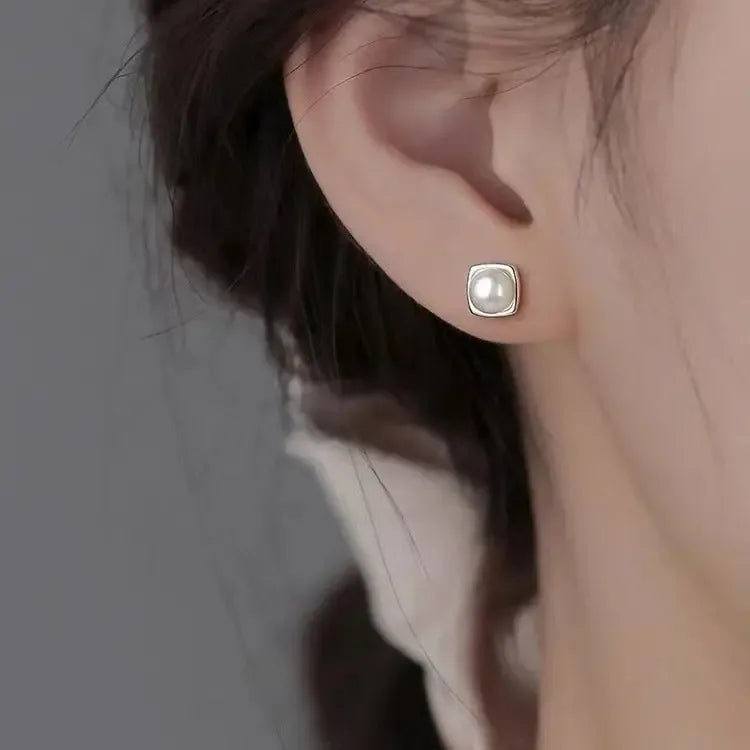 Sterling silver pearl stud earrings featuring minimalist geometric design, elegant jewelry for women.