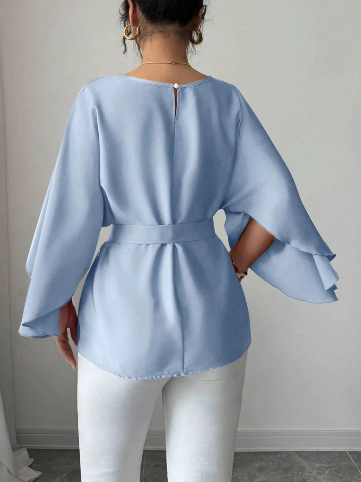 Batwing sleeve belted blouse from Plush Fashion Hub, shown in a stylish black top with flowy sleeves and a waist belt.