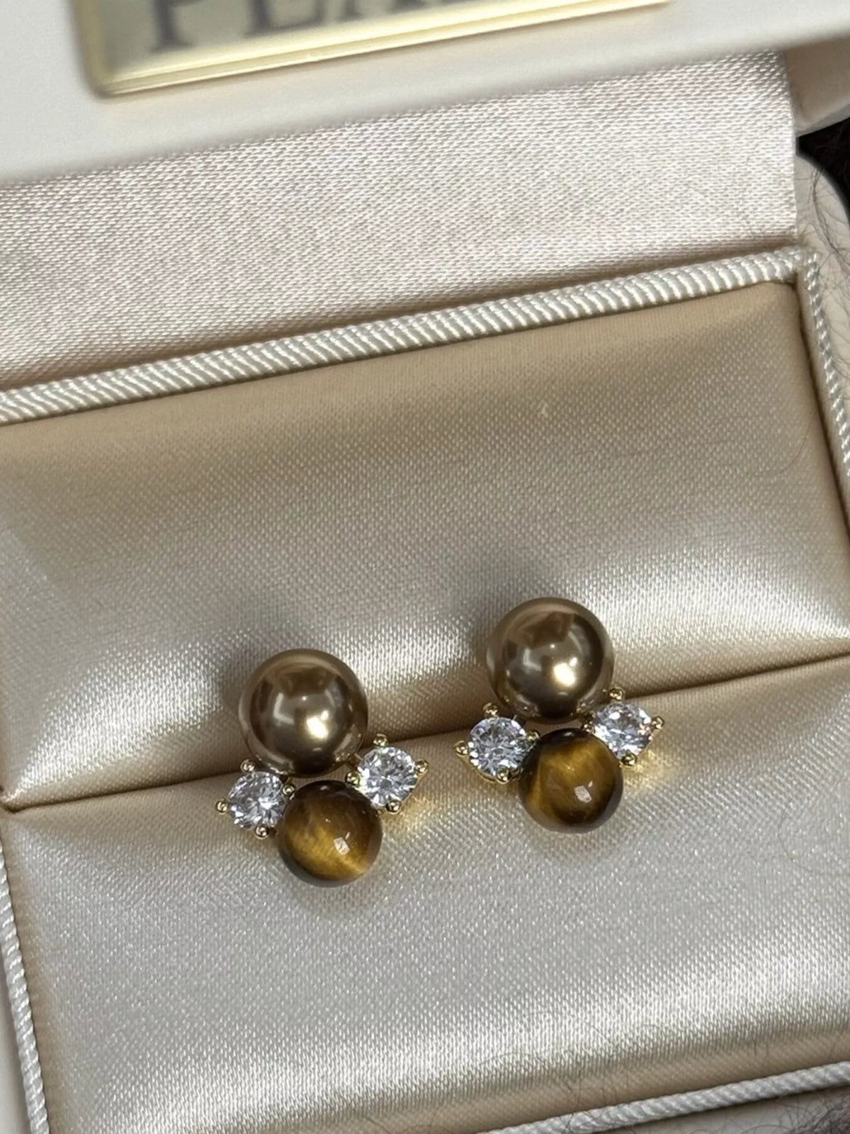 Plush Fashion Hub tiger eye stud earrings featuring polished, oval-shaped gemstone earrings with gold-tone posts.