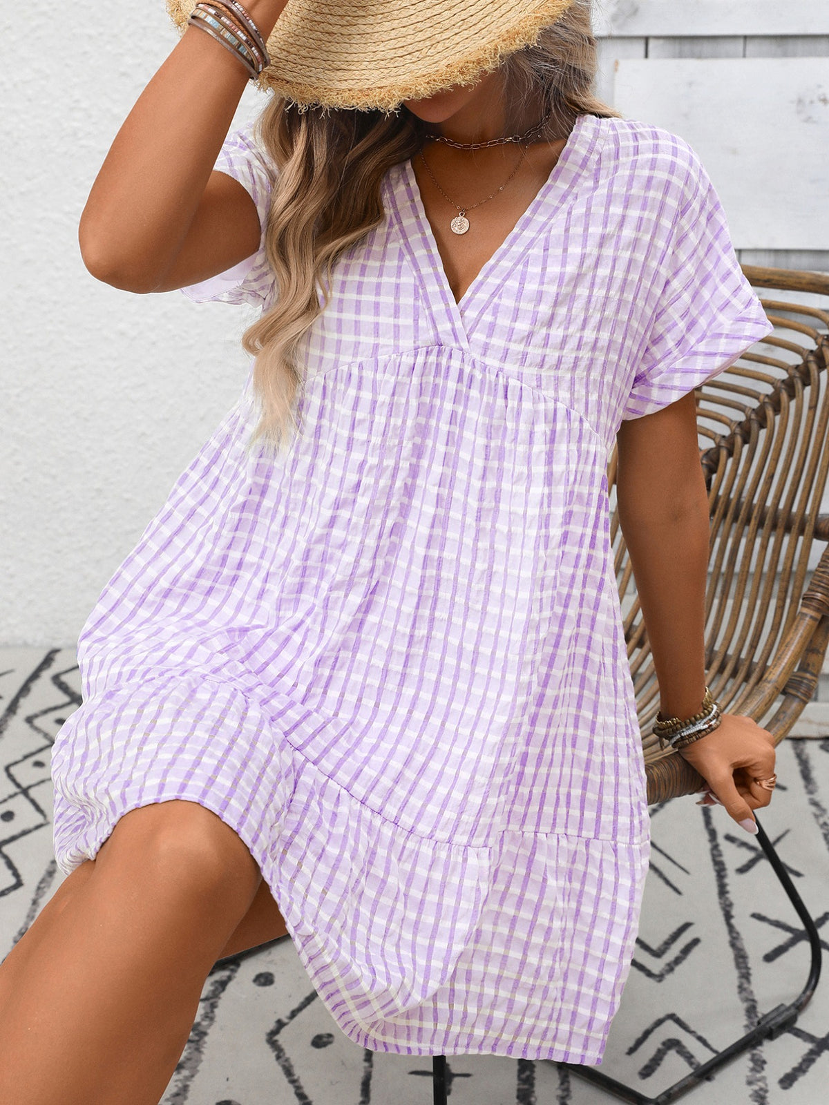 Plaid V-neck mini dress with ruffle hem by Plush Fashion Hub, featuring a stylish and feminine design perfect for casual or dressy occasions.