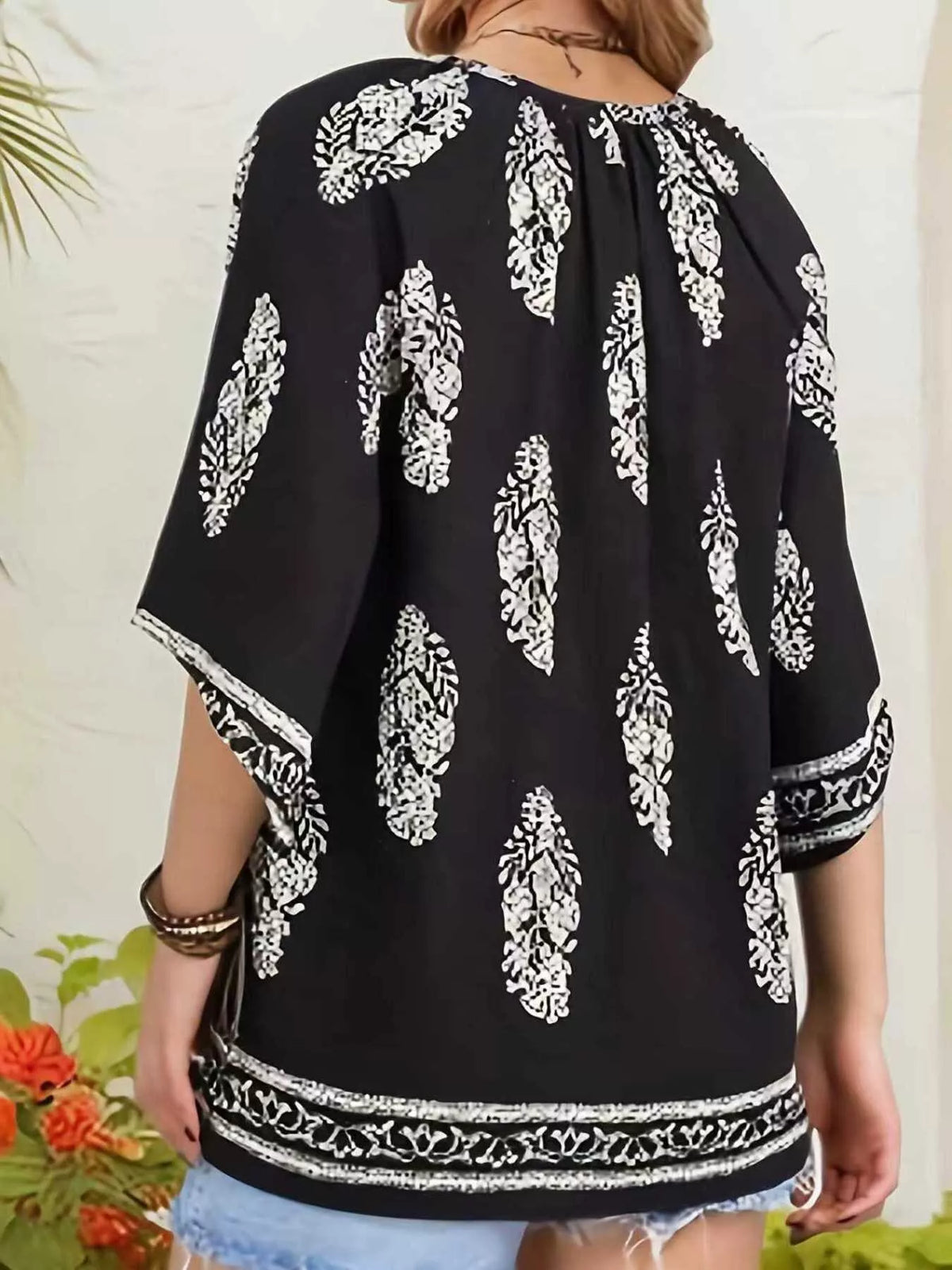 Printed notched 3/4 sleeve blouse by Plush Fashion Hub, showcasing a stylish design with a notched collar and comfortable fit.