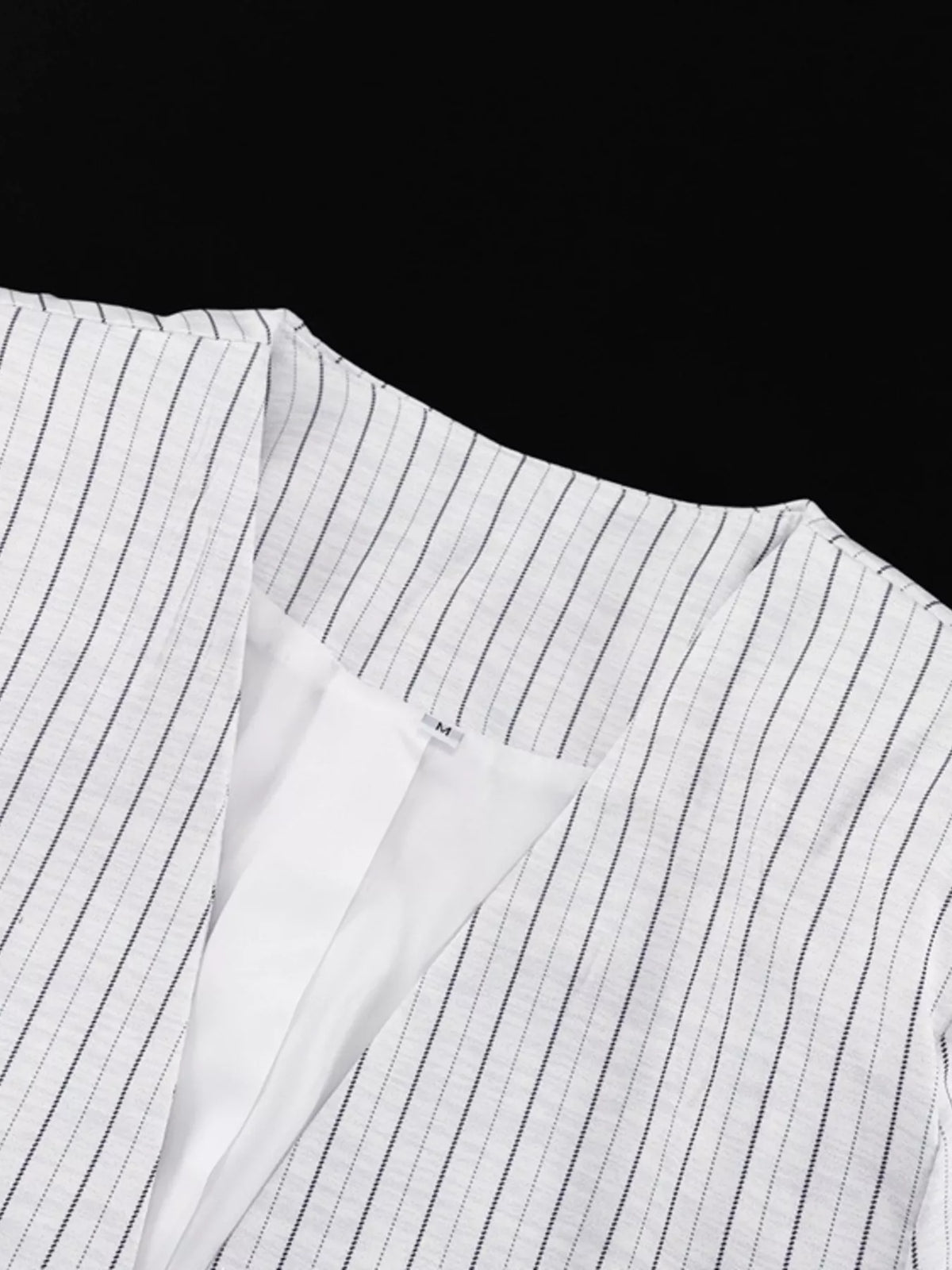 Pinstripe cropped blazer and pleated shorts set by Trendsi, featuring a stylish tailored blazer and matching pleated shorts.