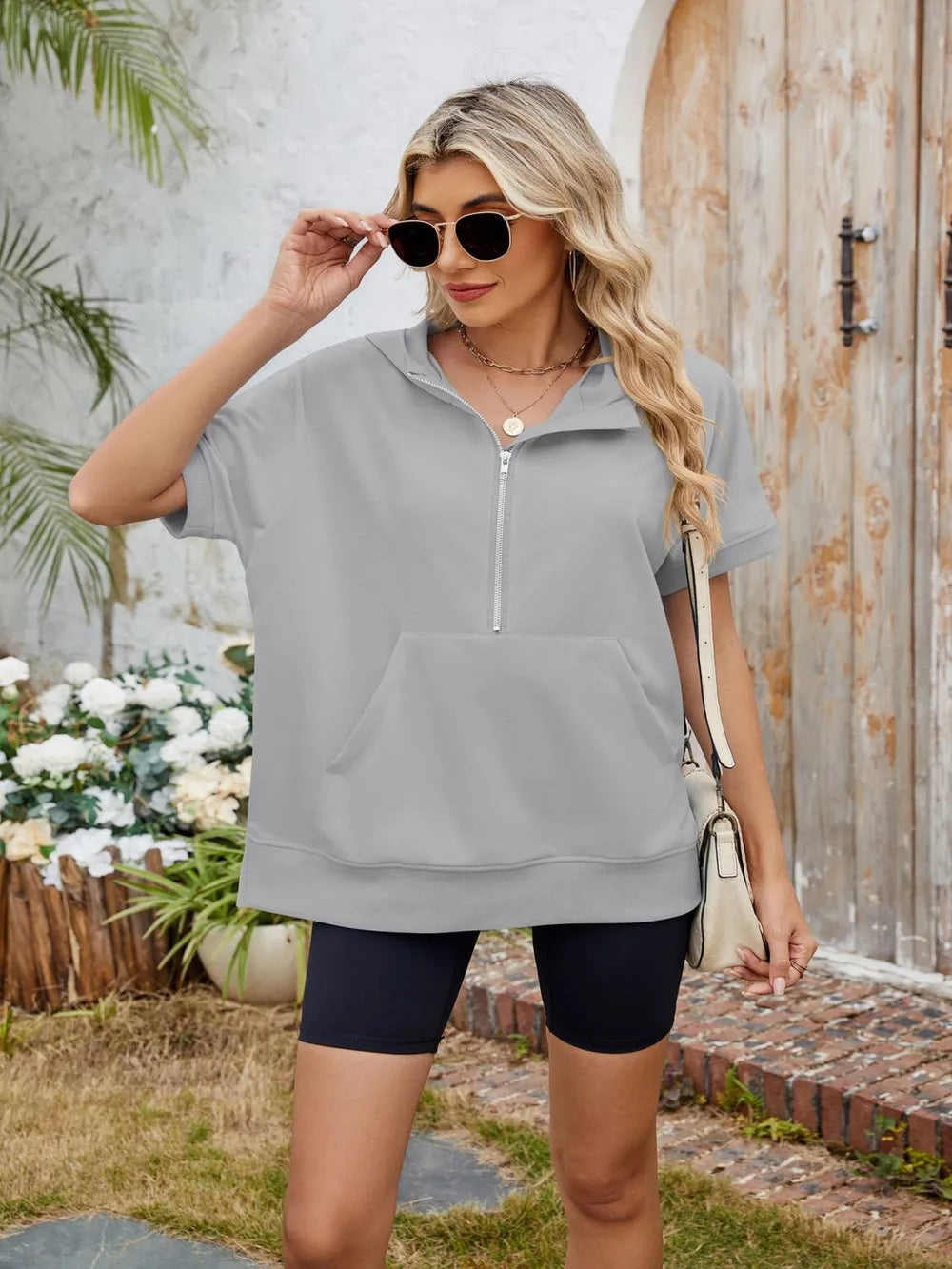 Short sleeve hooded half zip top by Plush Fashion Hub, featuring a casual design with a hood and half-zip closure.