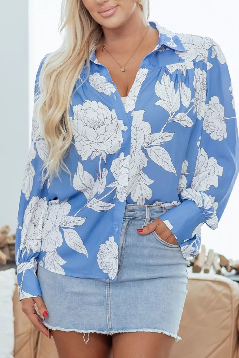 Women's floral print button-up shirt from Trendsi, featuring a colorful, lightweight blouse with long sleeves and a collar.