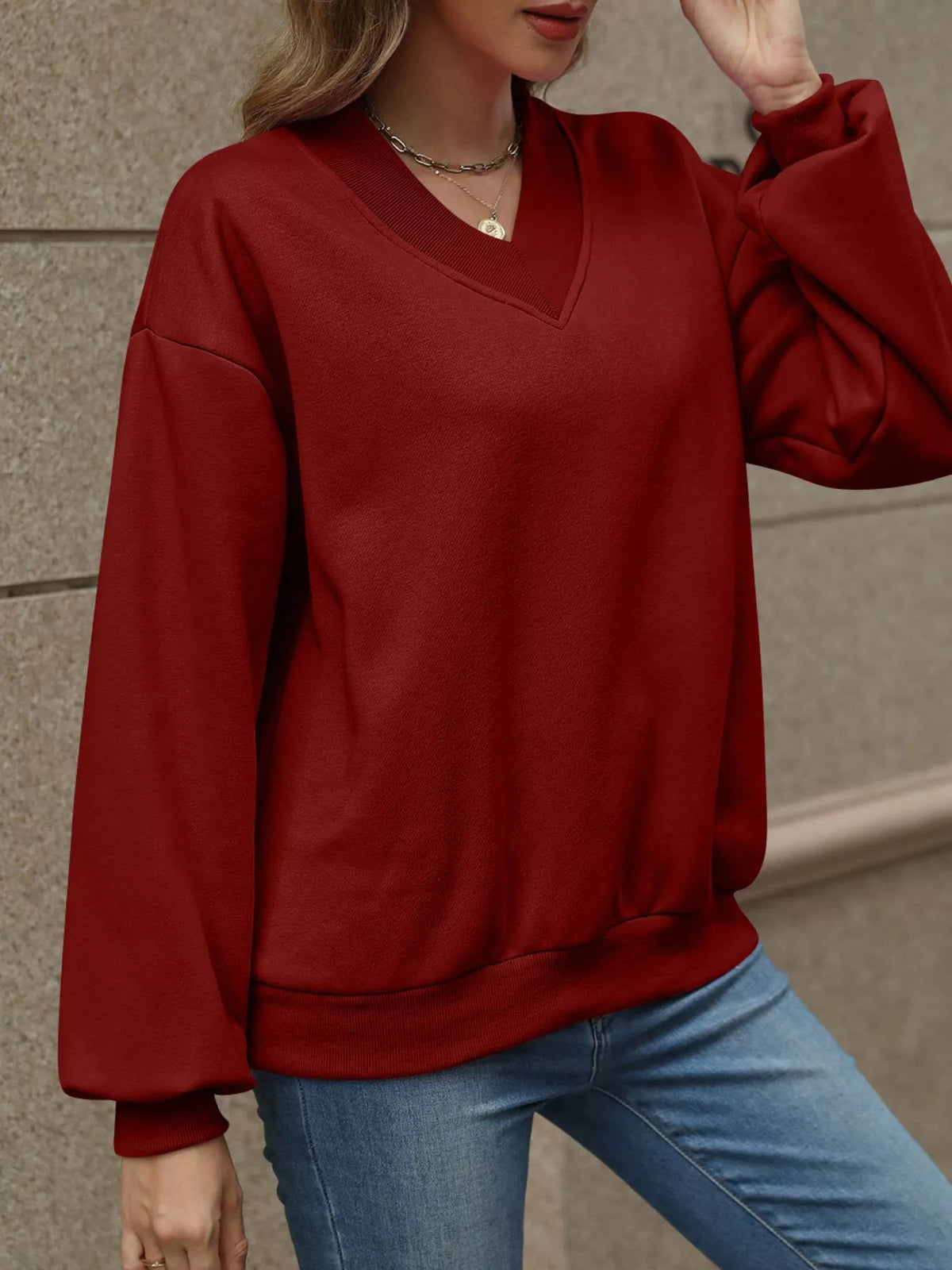 V-neck solid color casual sweatshirt by Trendsi, shown in a relaxed fit with long sleeves and soft fabric.