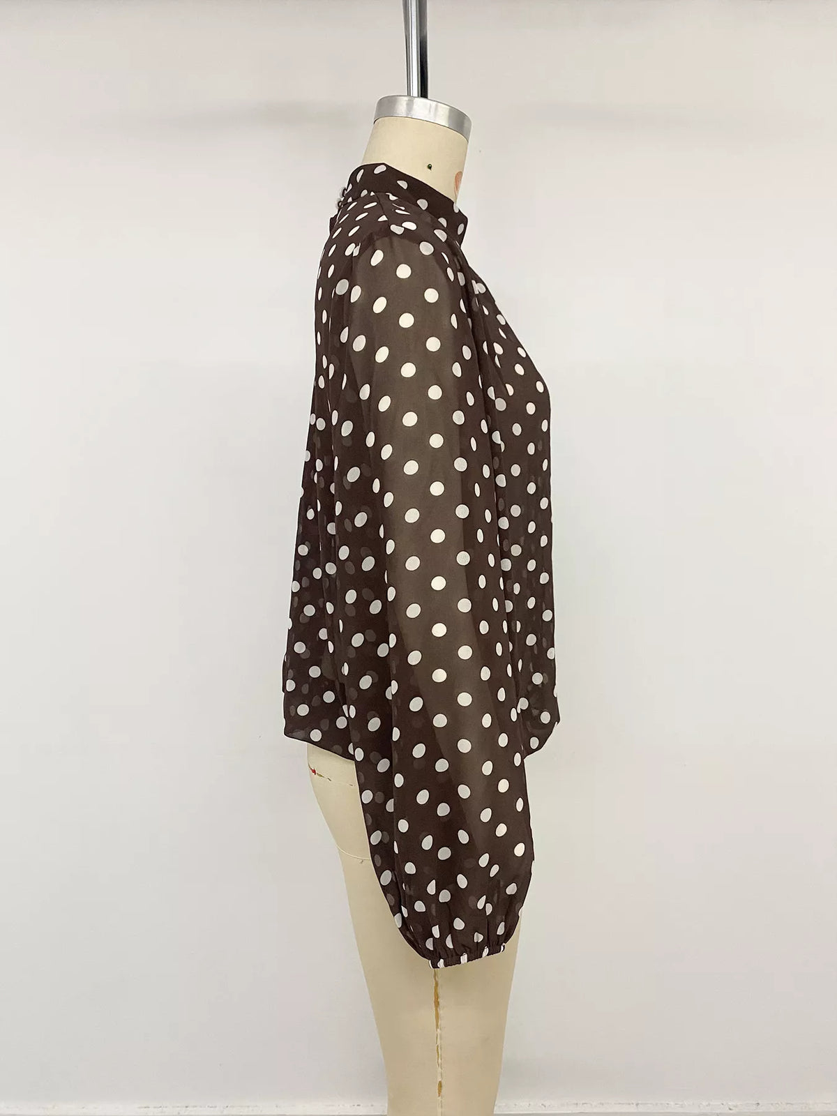 Polka dot mock neck long sleeve blouse by Trendsi featuring a stylish design and classic pattern, shown in the product image.
