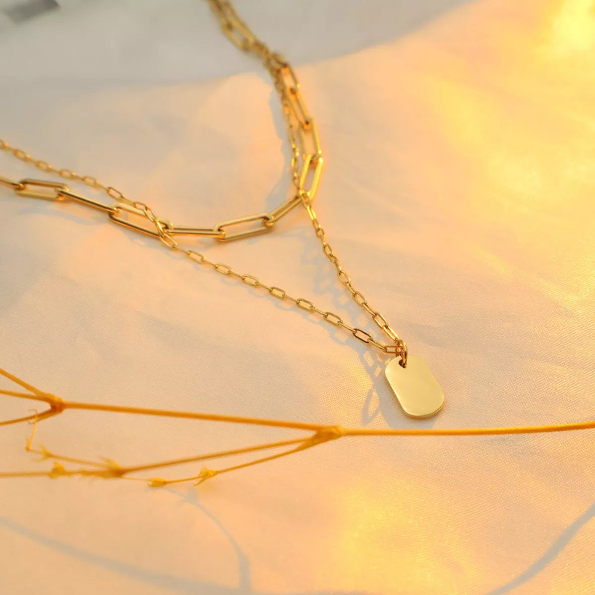 18K gold-plated double layered necklace with delicate chain and pendant, showcasing elegant jewelry design.