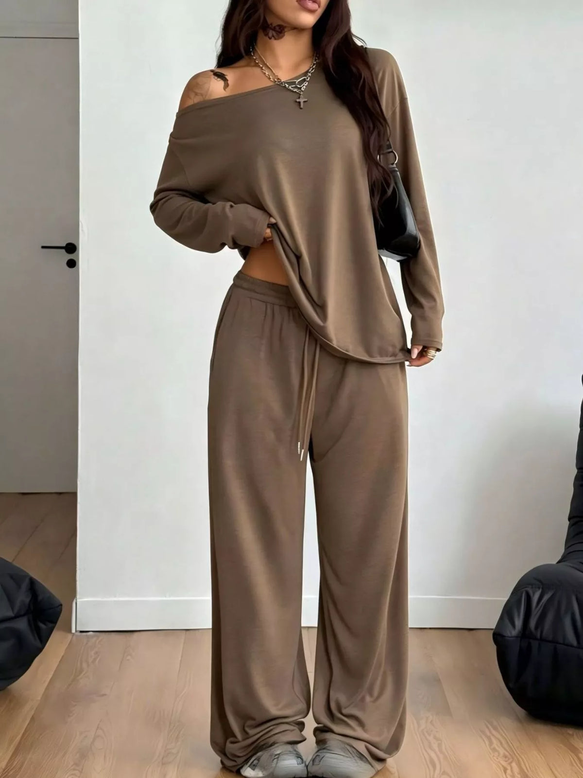 Plus size one-shoulder top and drawstring pants set from Trendsi, featuring a stylish matching outfit with a feminine silhouette.