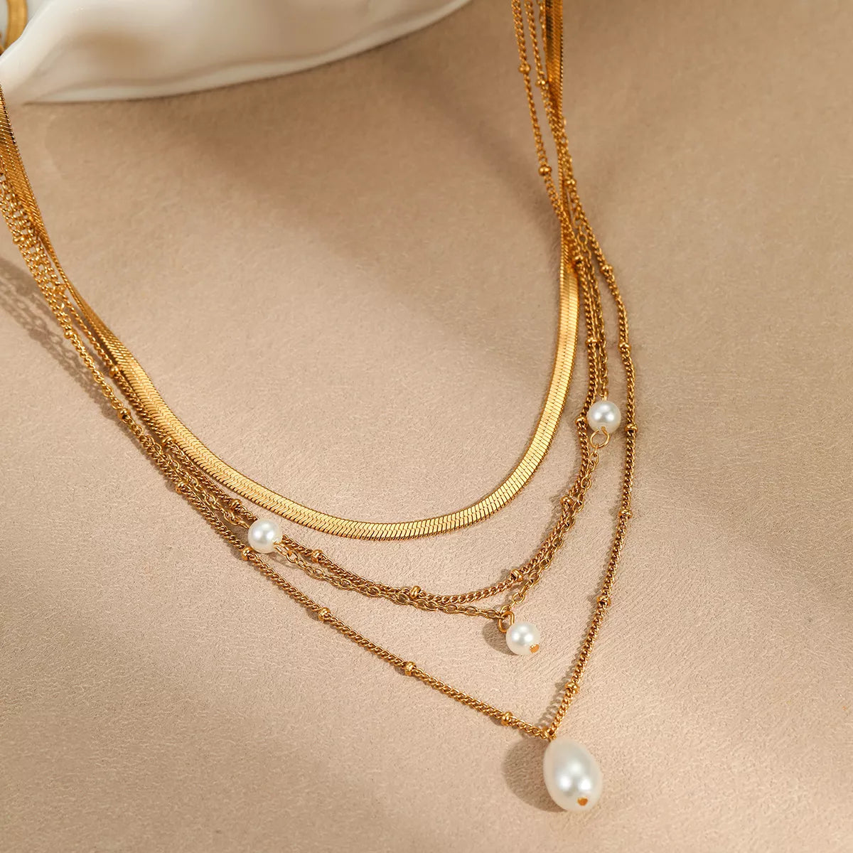 18K gold-plated four-layered pearl necklace with white pearls and gold accents, featuring a luxurious and elegant design.