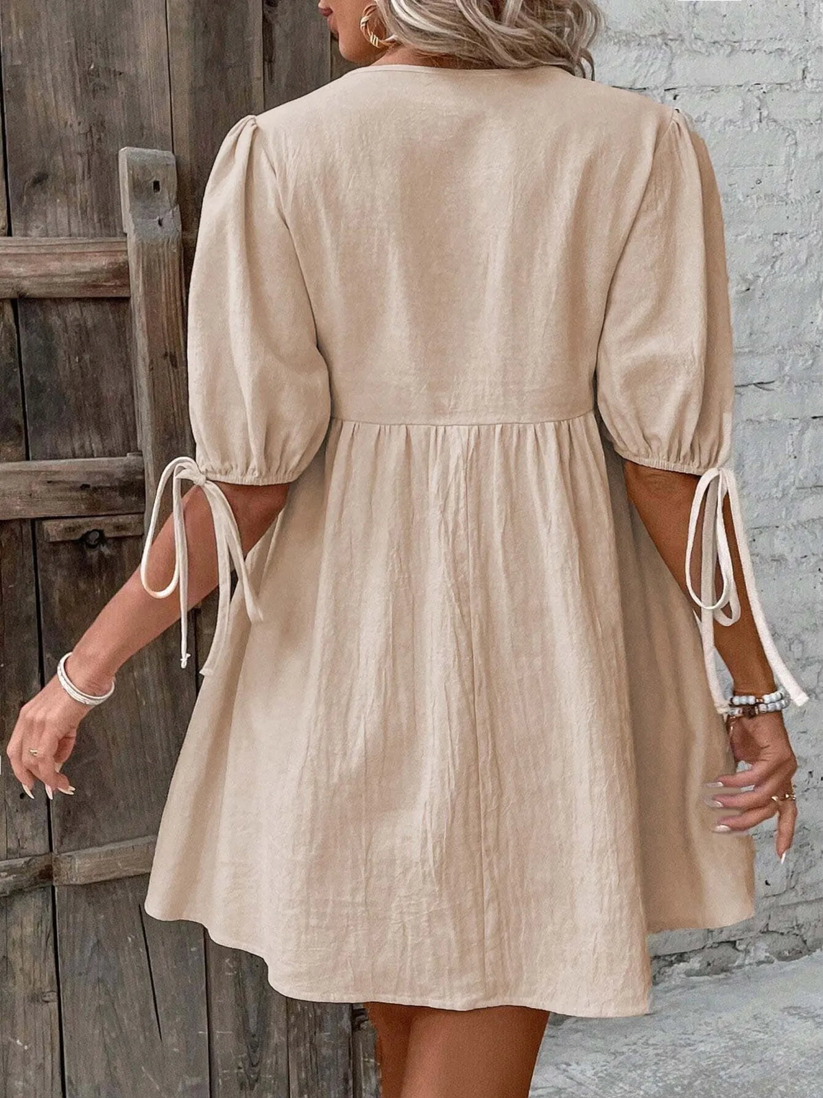 Cotton V-neck tie-front mini dress with puff sleeves by Plush Fashion Hub, showcasing a stylish and casual summer look.