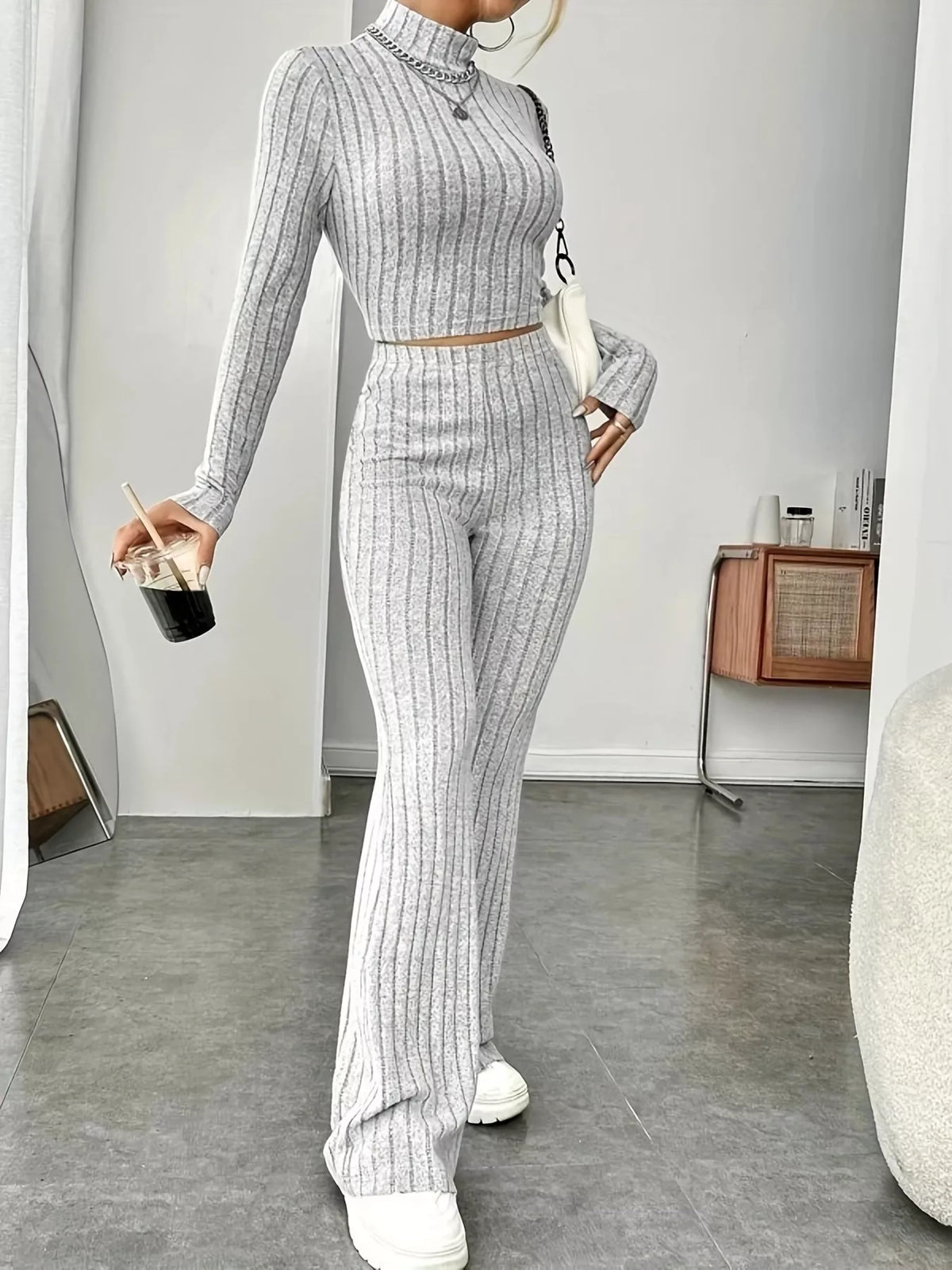 Ribbed turtleneck crop top and flare pants sweater set by Trendsi, featuring a fitted crop top and wide-leg pants in a cozy knit fabric.