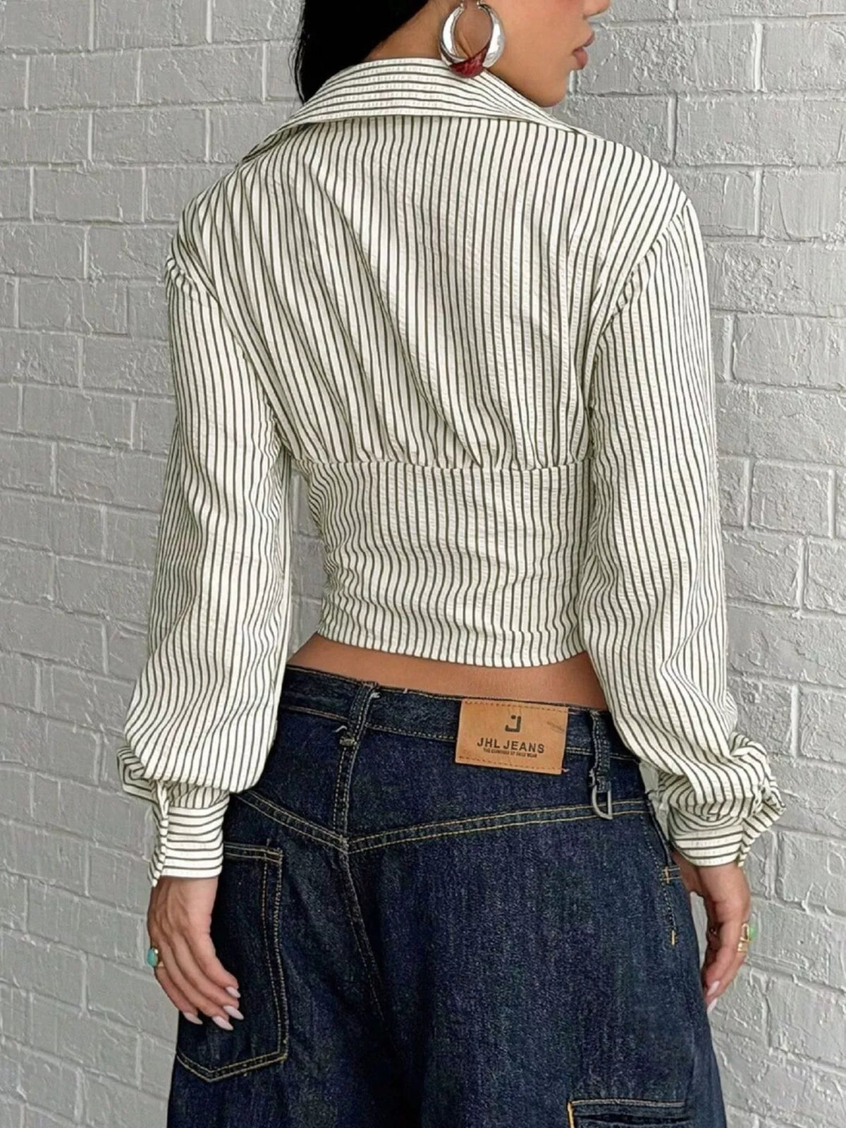 Deep V-neck striped long sleeve blouse from Trendsi, showing a stylish top with a fitted silhouette and bold horizontal stripes.