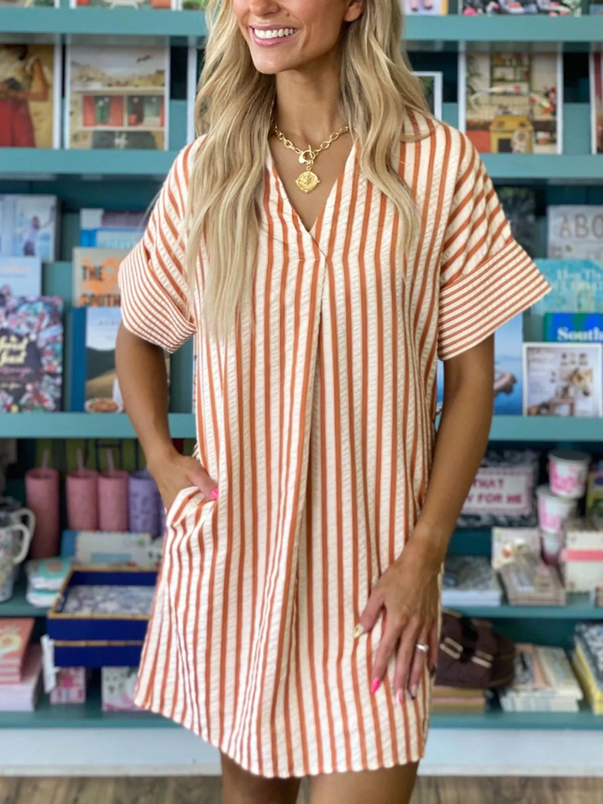 Striped V-neck mini dress by Plush Fashion Hub featuring turn-up cuffs and practical pockets, perfect for casual wear.